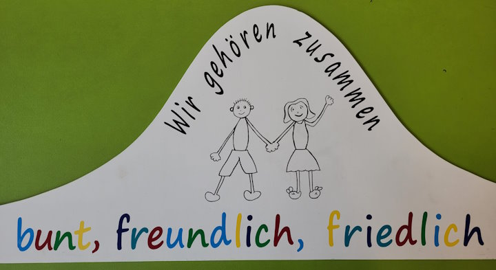 Das Schild der Schule: Wir gehören zusammen - bunt, freundlich, friedlich